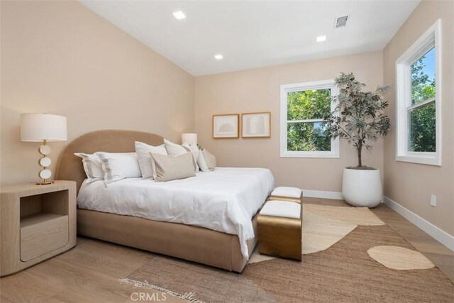 bedroom featuring wood finished floors, baseboards, and recessed lighting