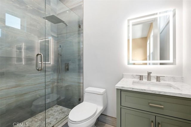 bathroom with toilet, a stall shower, and vanity