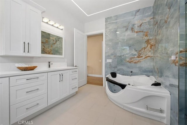 bathroom with vanity, a tub with jets, and tile patterned floors