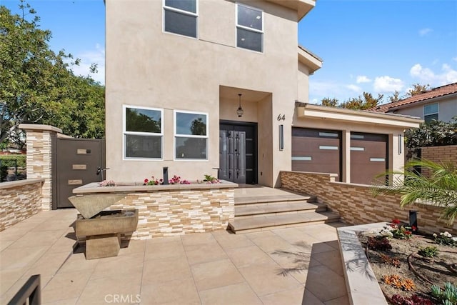 property entrance featuring stucco siding and french doors