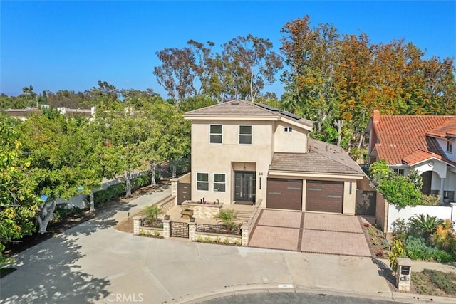 view of front of property with driveway, stucco siding, roof mounted solar panels, and an attached garage
