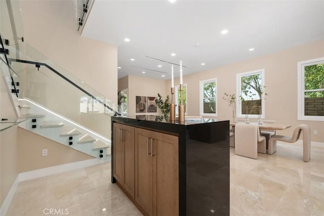 kitchen with baseboards, recessed lighting, dark countertops, and a center island