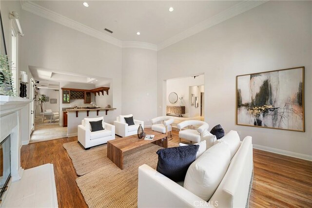 15850 Seville Ln, Encino, CA 91436 - living area with wood finished floors, recessed lighting, crown molding, baseboards, and a tile fireplace