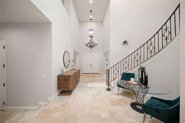 15850 Seville Ln, Encino, CA 91436 - entryway with stairway, baseboards, a towering ceiling, a chandelier, and stone finish flooring