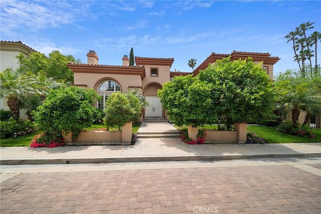 15850 Seville Ln, Encino, CA 91436 - mediterranean / spanish house with stucco siding, a chimney, and a tile roof