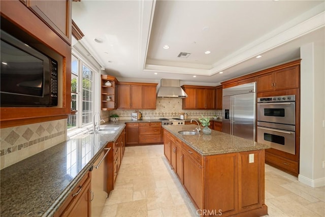 15850 Seville Ln, Encino, CA 91436 - kitchen featuring built in appliances, wall chimney range hood, a tray ceiling, a sink, and recessed lighting