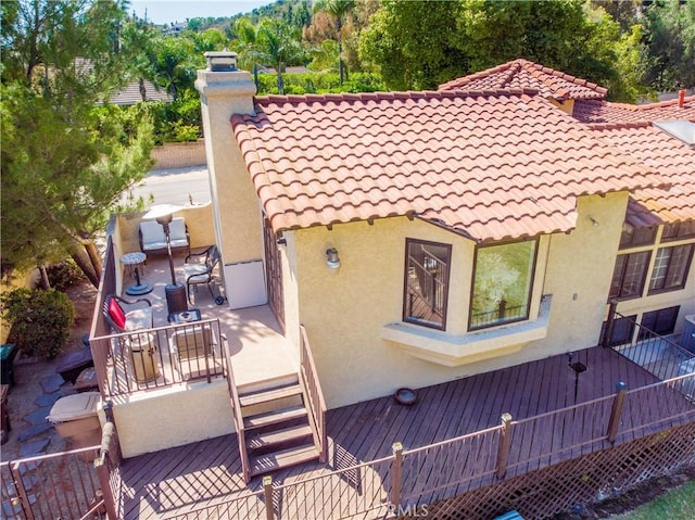 9092 S Rama St, Villa Park, CA 92861 - back of house featuring stucco siding, a chimney, a tile roof, and a wooden deck