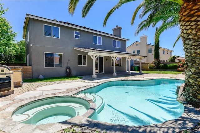 view of pool featuring a pool with connected hot tub, a patio, and fence