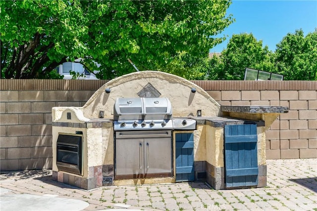 view of patio with an outdoor kitchen, grilling area, and fence