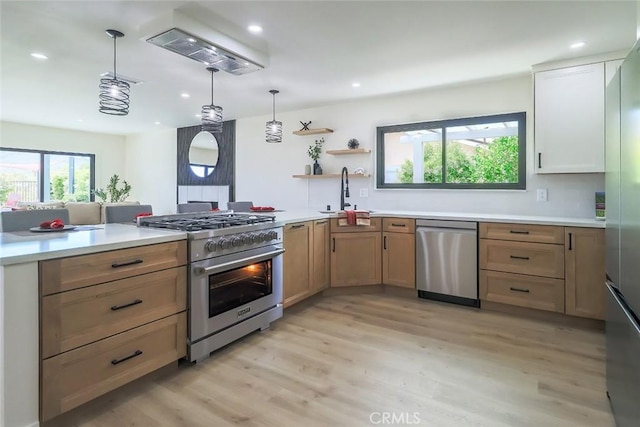 kitchen with stainless steel appliances, a sink, light wood-style flooring, light countertops, and recessed lighting
