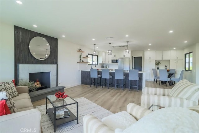 26120 Adamor Rd, Calabasas, CA 91302 - living room with light wood-type flooring, recessed lighting, baseboards, and a tiled fireplace