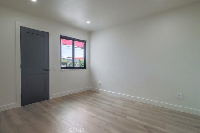 unfurnished room featuring light wood-style floors, recessed lighting, and baseboards