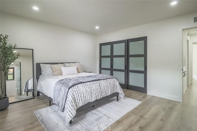 bedroom with light wood-style floors and recessed lighting