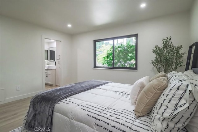 bedroom featuring light wood-style floors, recessed lighting, baseboards, and connected bathroom