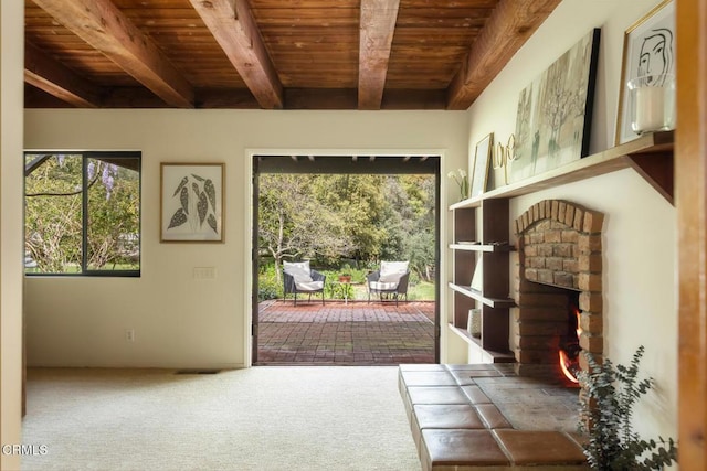 doorway with wood ceiling, healthy amount of natural light, beam ceiling, a fireplace, and carpet flooring