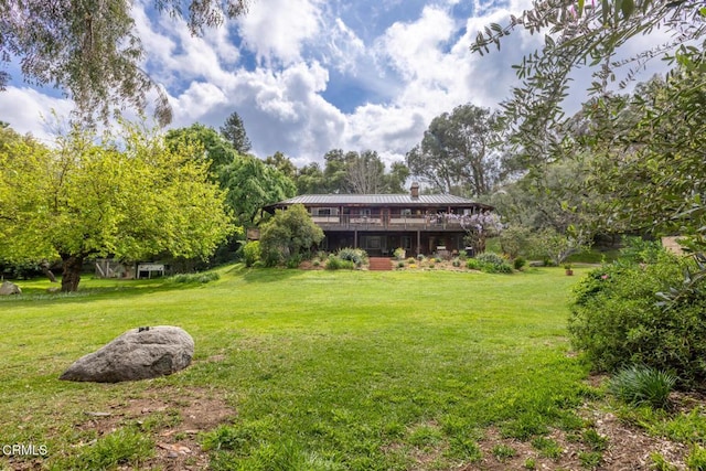 view of grassy yard with a wooden deck
