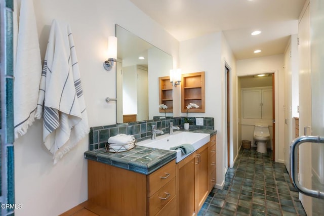 bathroom featuring vanity, toilet, recessed lighting, tasteful backsplash, and baseboards