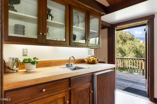 bar area with a sink and refrigerator