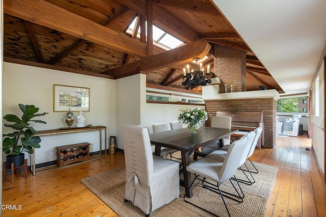 dining space featuring hardwood / wood-style floors, a chandelier, a brick fireplace, and wooden ceiling