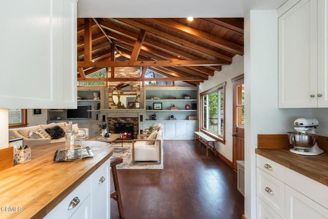 kitchen with wood counters, open floor plan, dark wood-style flooring, white cabinets, and wooden ceiling