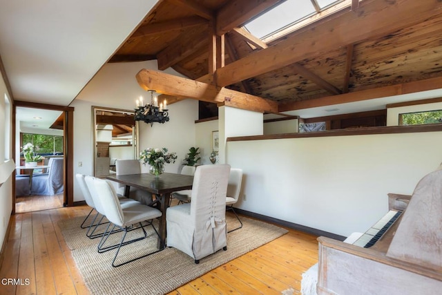 dining space featuring hardwood / wood-style floors, a chandelier, and baseboards