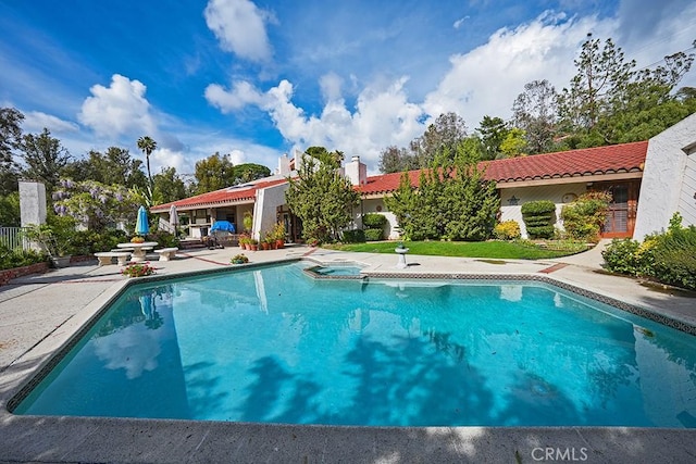 outdoor pool featuring a patio area and an in-ground hot tub