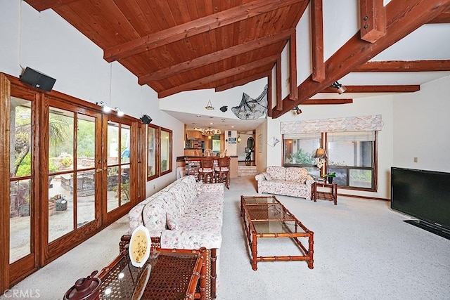 carpeted living room with healthy amount of natural light, wooden ceiling, french doors, high vaulted ceiling, and beamed ceiling