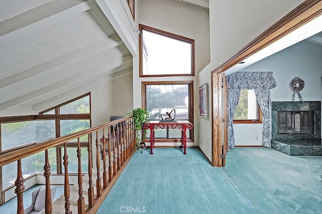 hall featuring carpet flooring, high vaulted ceiling, beamed ceiling, and baseboards