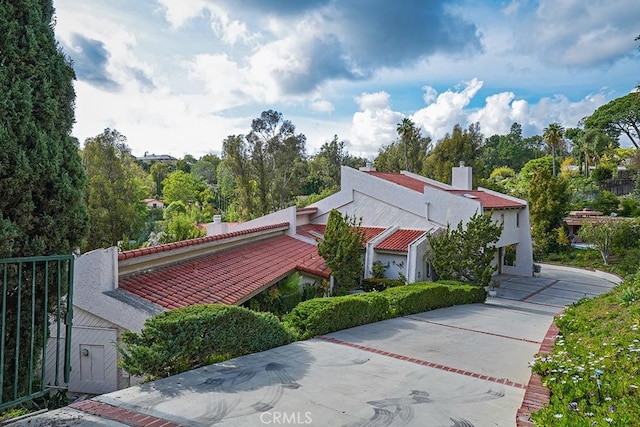 view of side of property with a chimney, stucco siding, and a tile roof