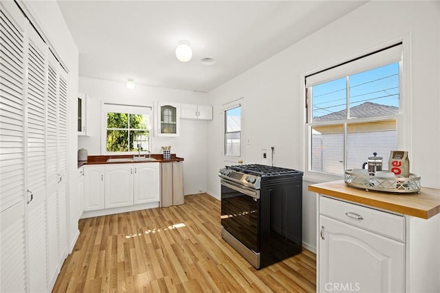 333 W Andrix St, Monterey Park, CA 91754 - kitchen featuring stainless steel gas stove, wooden counters, light wood-style floors, glass insert cabinets, and white cabinets