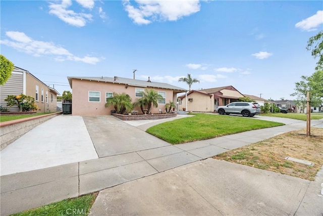 5927 Mckinley Ave, South Gate, CA 90280 - view of front facade with concrete driveway, stucco siding, a front lawn, and a residential view