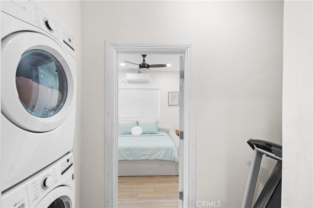 5927 Mckinley Ave, South Gate, CA 90280 - laundry room featuring stacked washer and clothes dryer, a wall unit AC, wood finished floors, and ceiling fan