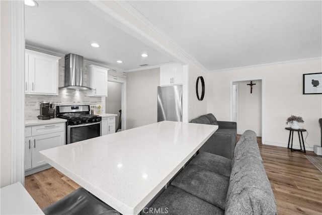 5927 Mckinley Ave, South Gate, CA 90280 - kitchen with wall chimney range hood, stainless steel appliances, ornamental molding, white cabinets, and decorative backsplash