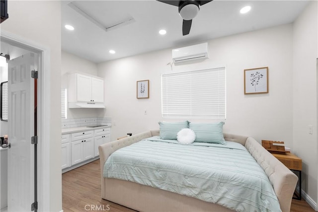 5927 Mckinley Ave, South Gate, CA 90280 - bedroom with an AC wall unit, attic access, light wood-style flooring, recessed lighting, and a ceiling fan