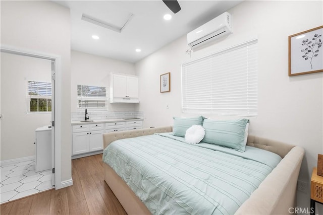 5927 Mckinley Ave, South Gate, CA 90280 - bedroom featuring attic access, a wall mounted air conditioner, a sink, light wood-type flooring, and recessed lighting