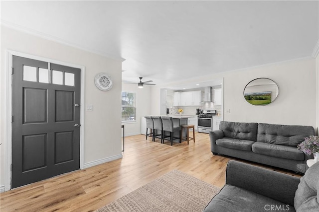 5927 Mckinley Ave, South Gate, CA 90280 - living area with ornamental molding, light wood-style flooring, ceiling fan, and baseboards