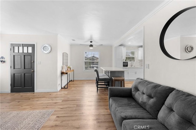 5927 Mckinley Ave, South Gate, CA 90280 - living area with ornamental molding, ceiling fan, light wood-style floors, and baseboards