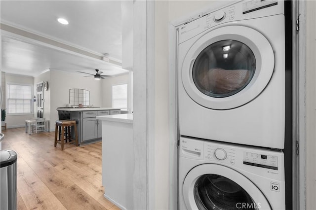 5927 Mckinley Ave, South Gate, CA 90280 - washroom with estacked washer and dryer, light wood-style flooring, ceiling fan, ornamental molding, and baseboards