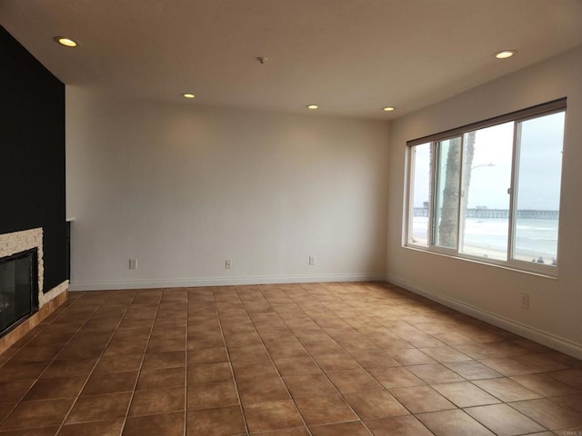 600 N The Strand Unit 12, Oceanside, CA 92054 - unfurnished living room featuring recessed lighting, a tile fireplace, and baseboards