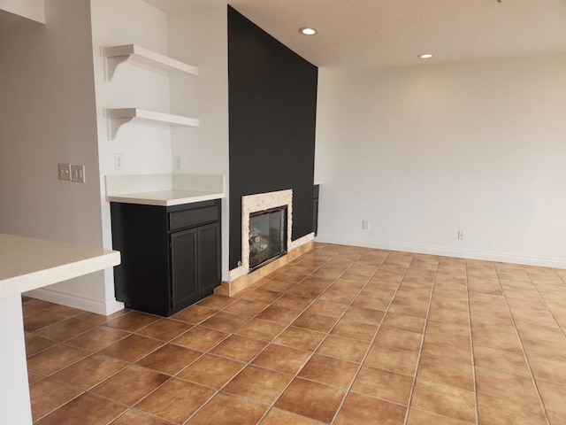 600 N The Strand Unit 12, Oceanside, CA 92054 - unfurnished living room with a glass covered fireplace, recessed lighting, tile patterned flooring, and baseboards