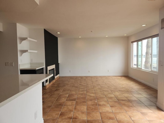 600 N The Strand Unit 12, Oceanside, CA 92054 - empty room featuring recessed lighting, a glass covered fireplace, baseboards, and tile patterned floors