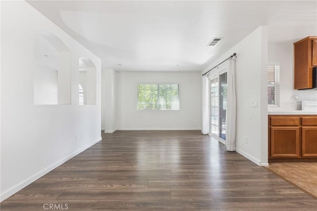 25892 Iris Ave Unit A, Moreno Valley, CA 92551 - unfurnished living room with dark wood-type flooring, baseboards, and arched walkways