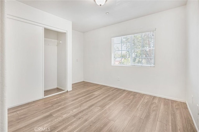 25892 Iris Ave Unit A, Moreno Valley, CA 92551 - unfurnished bedroom featuring light wood finished floors, a closet, and baseboards