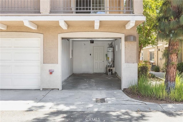 25892 Iris Ave Unit A, Moreno Valley, CA 92551 - property entrance with stucco siding, a balcony, strapped water heater, and an attached garage