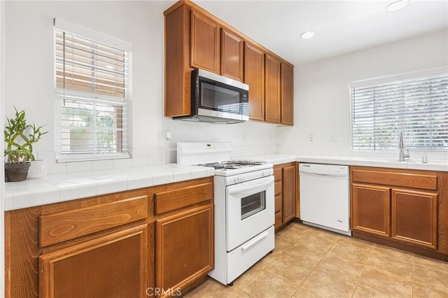 25892 Iris Ave Unit A, Moreno Valley, CA 92551 - kitchen with white appliances, a sink, brown cabinets, recessed lighting, and light tile patterned floors