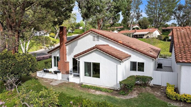 27751 Via Lorca, Mission Viejo, CA 92692 - back of house featuring a tiled roof, fence, and stucco siding