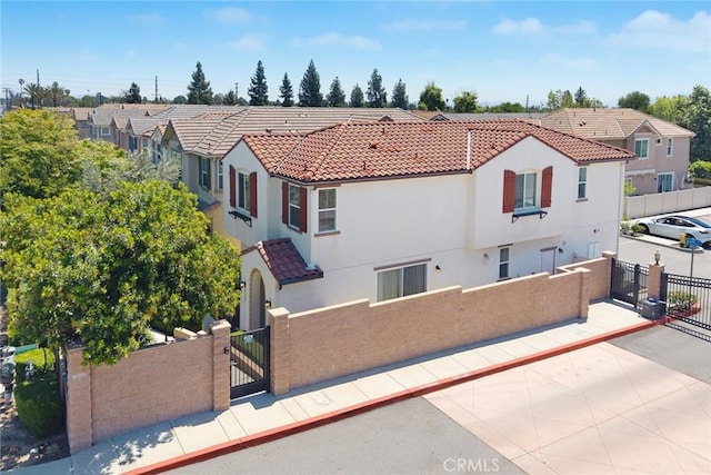 view of front of house featuring a fenced front yard, a gate, and stucco siding