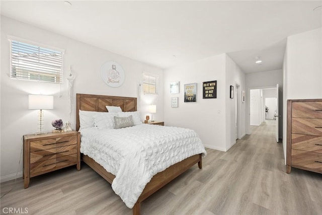 bedroom featuring light wood-type flooring and baseboards