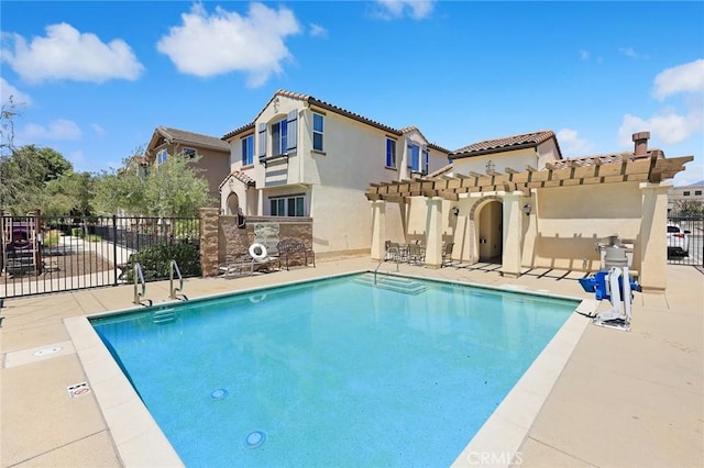 back of house featuring fence, a community pool, stucco siding, and a pergola