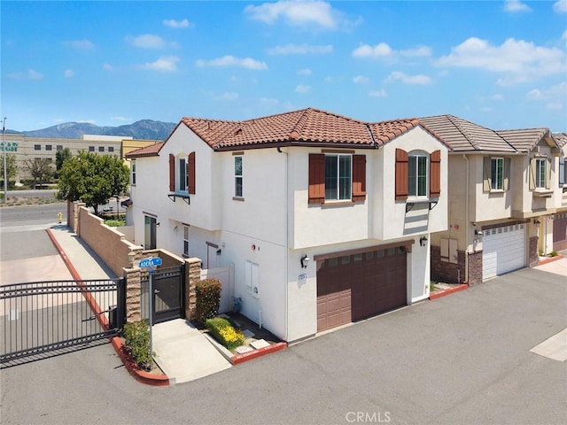 view of front of house with stucco siding, a mountain view, and an attached garage